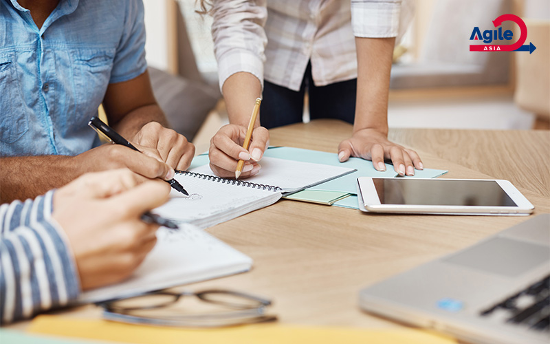 group of people working collaboratively at a table with notebooks