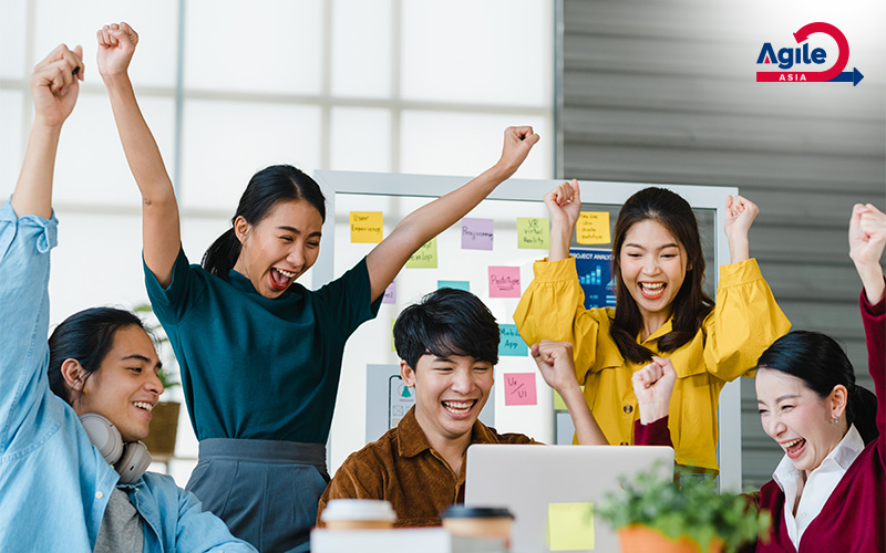 Agile Asia team celebrating project success at the office.