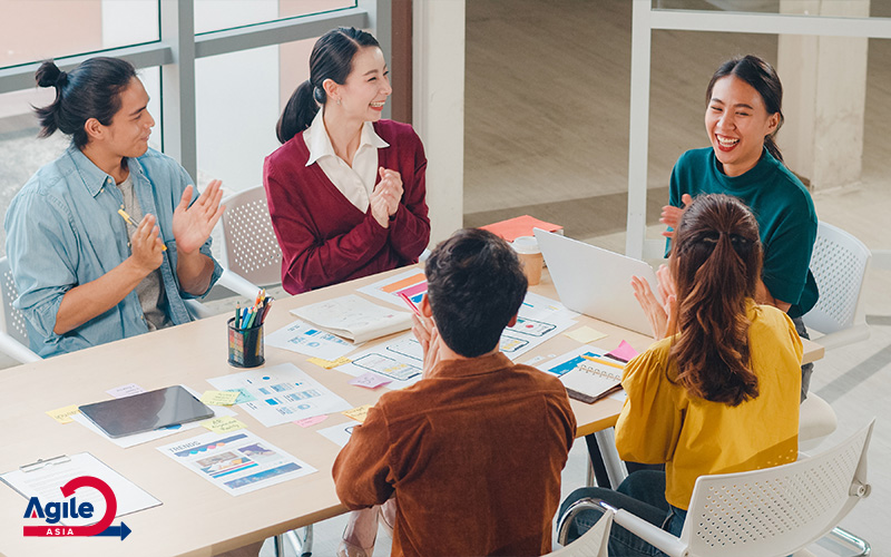 Agile team clapping during a collaborative meeting.