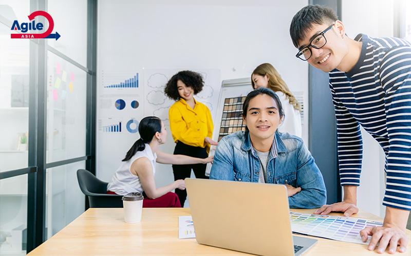 Agile team collaborating and smiling in a modern office.